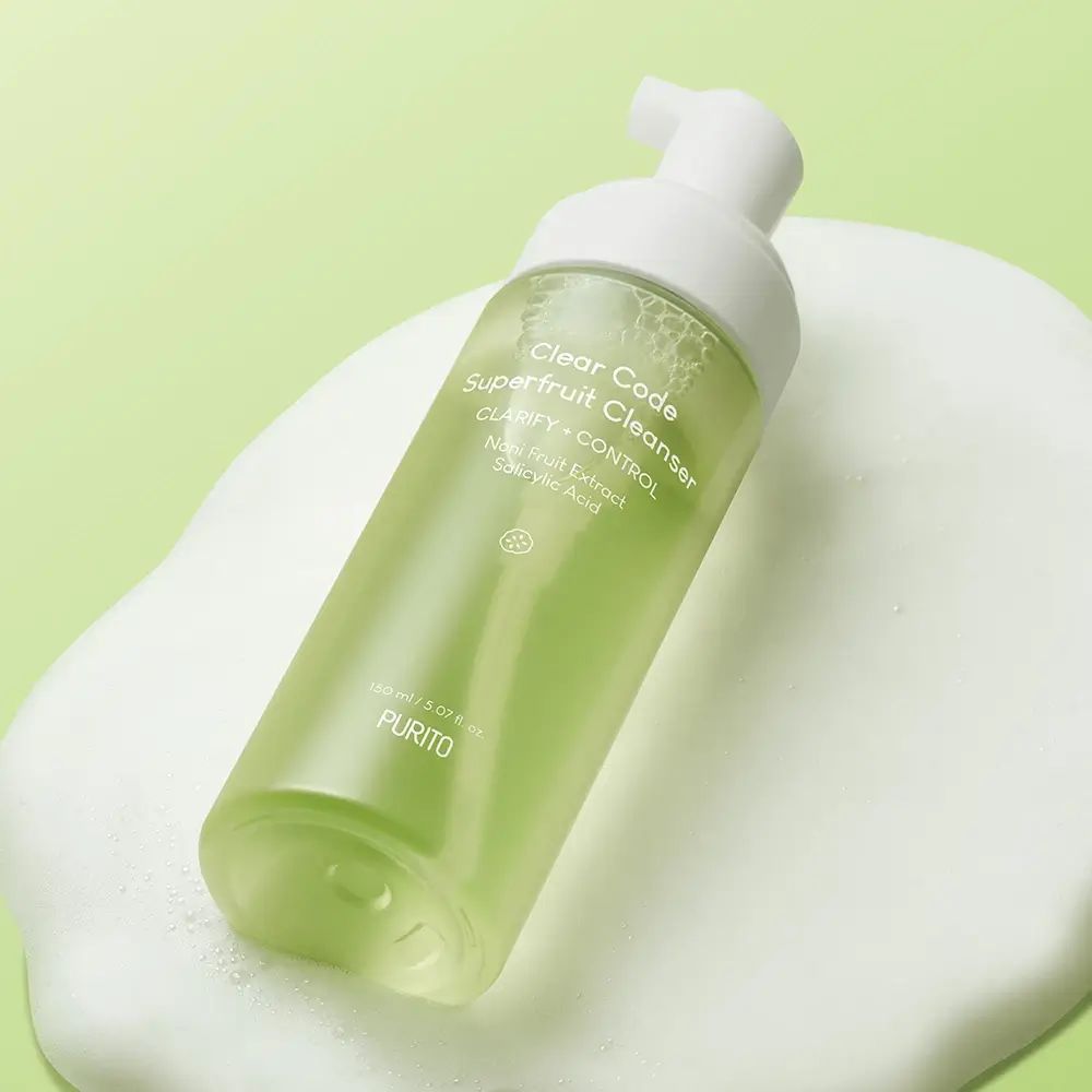 Flacone trasparente con dosatore bianco su schiuma. Scritta: Clear Code Superfruit Cleanser. Logo PURITO.
