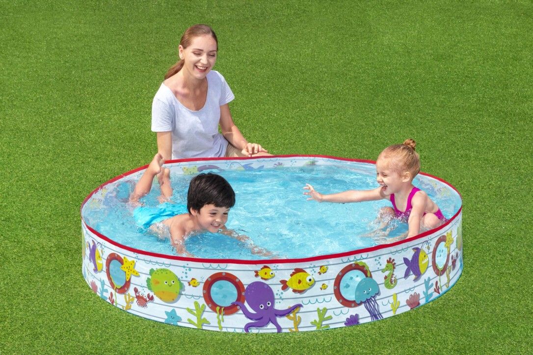 Piscina per bambini con motivo sottomarino, bambini e donna in piscina. Bordo rosso, acqua blu. Decorazioni marine.