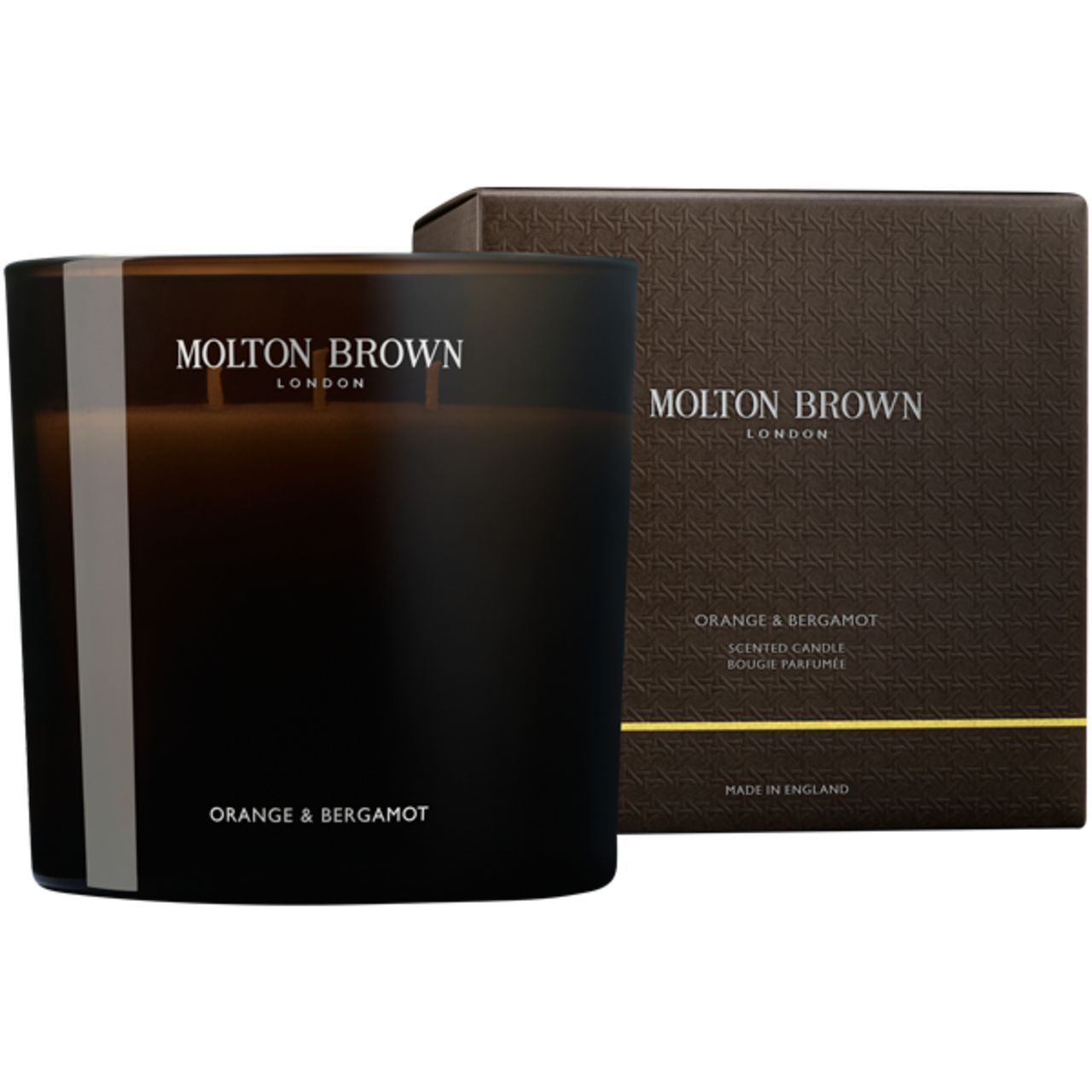 Candela profumata in vetro scuro con scatola. Scritta: Molton Brown, Orange & Bergamot. Scatola con logo e informazioni.