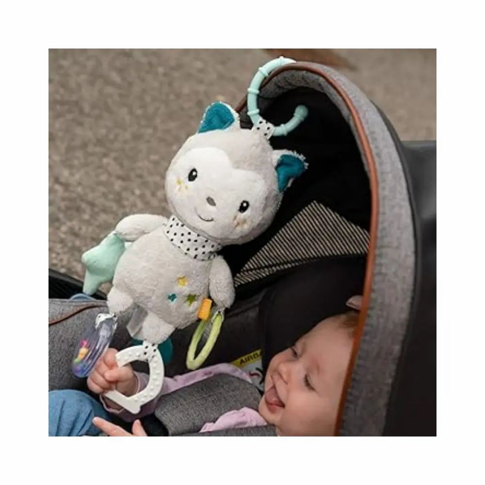 Bambino in carrozzina con peluche grigio. Peluche con orecchie blu, sciarpa a pois, stella, specchio e sonaglio.