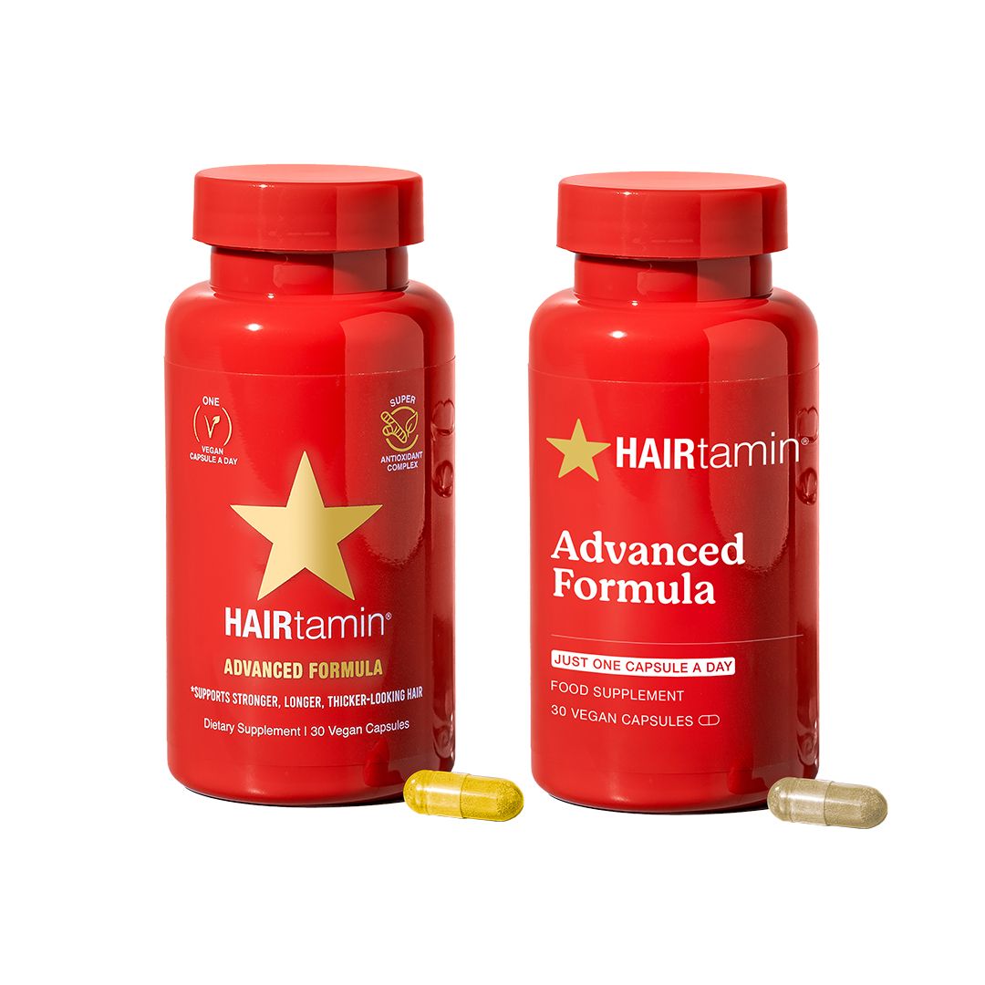 Due flaconi rossi HAIRtamin Advanced Formula. Scritta: Advanced Formula. Due capsule accanto. Logo: Vegan.