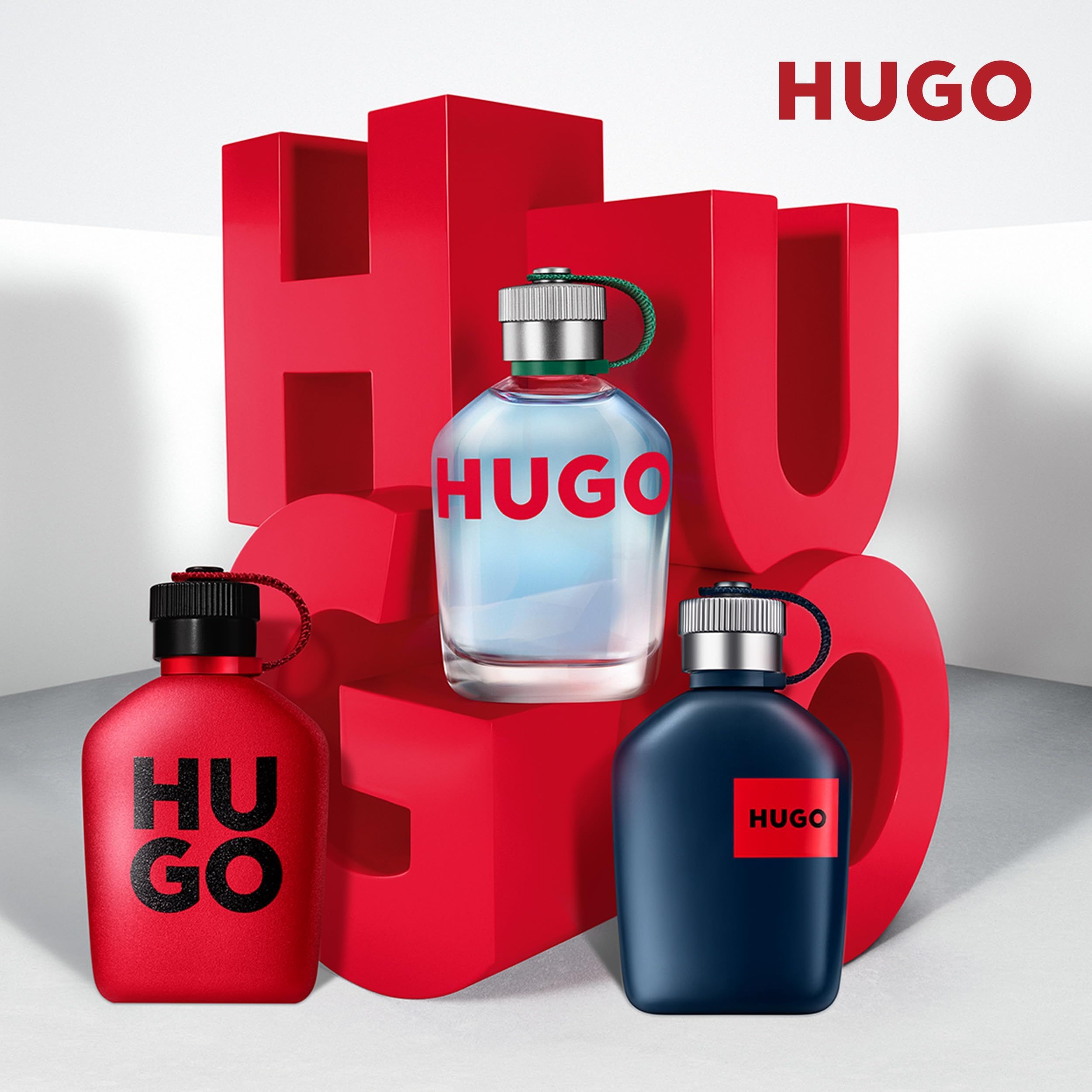 Tre flaconi Hugo in rosso, blu e trasparente. Lettere rosse 'HUGO' sullo sfondo.