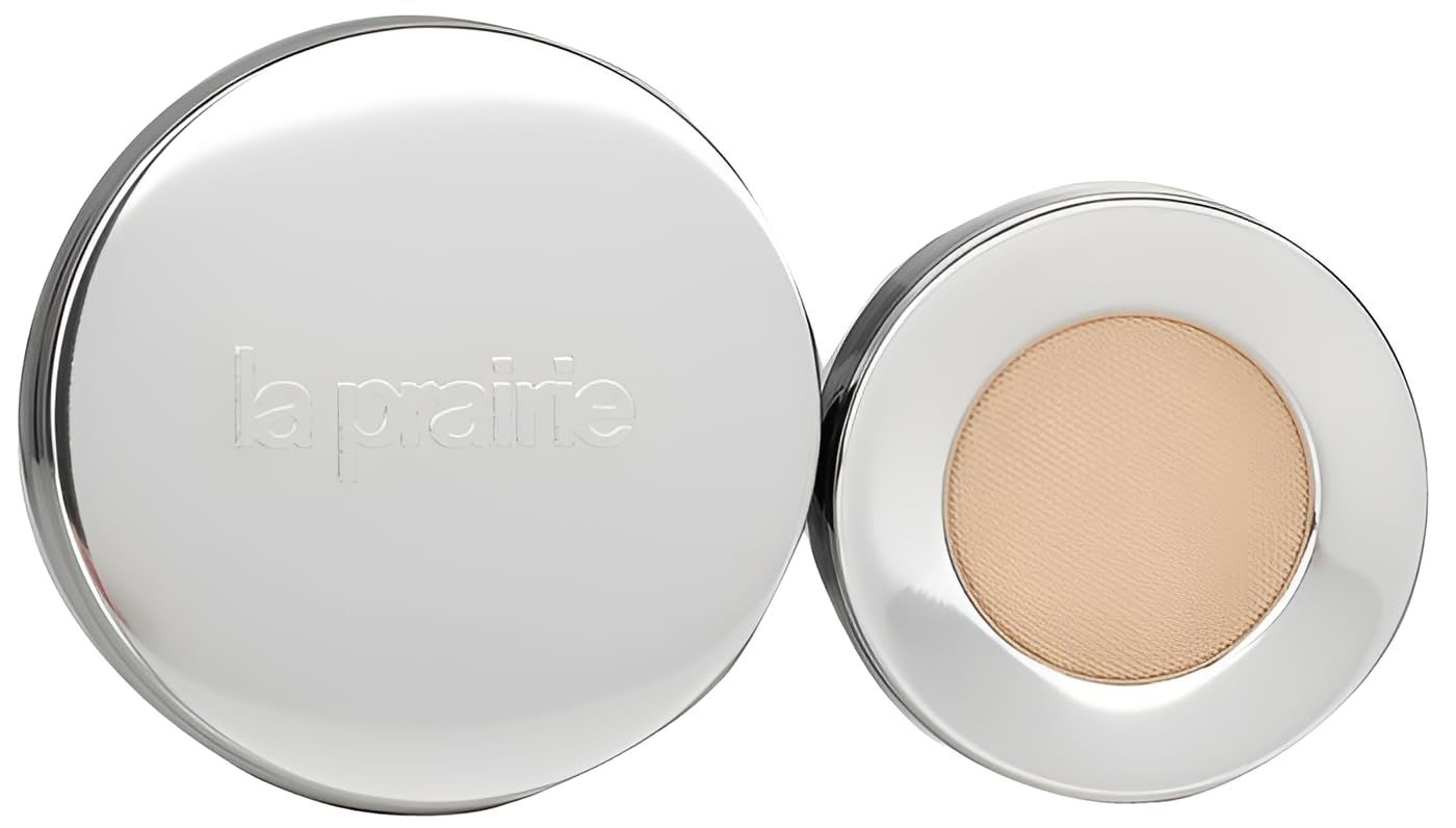 Contenitore rotondo argentato con logo La Prairie e cipria color beige chiaro.
