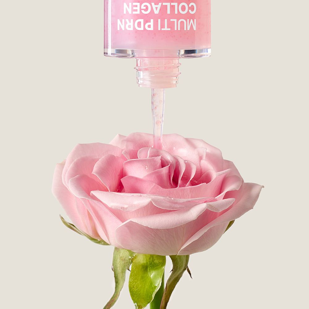 Il siero gocciola da un contagocce su una rosa rosa. Prodotto per la cura della pelle.