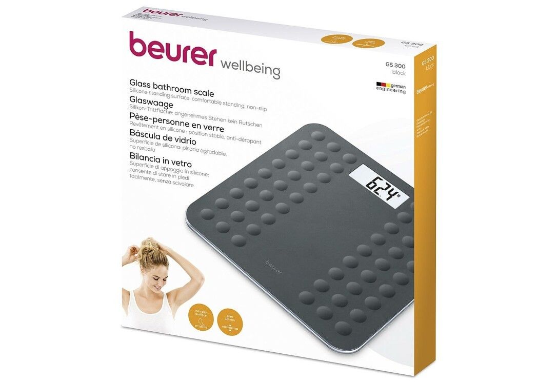 Confezione della bilancia in vetro. Marca: beurer. Nome prodotto: GS 300 Black. Immagine: bilancia, donna, loghi.