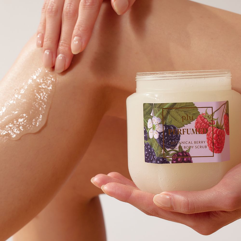 Persona che tiene un barattolo con coperchio dorato. Etichetta con illustrazione di frutti di bosco. Prodotto applicato sulla gamba.