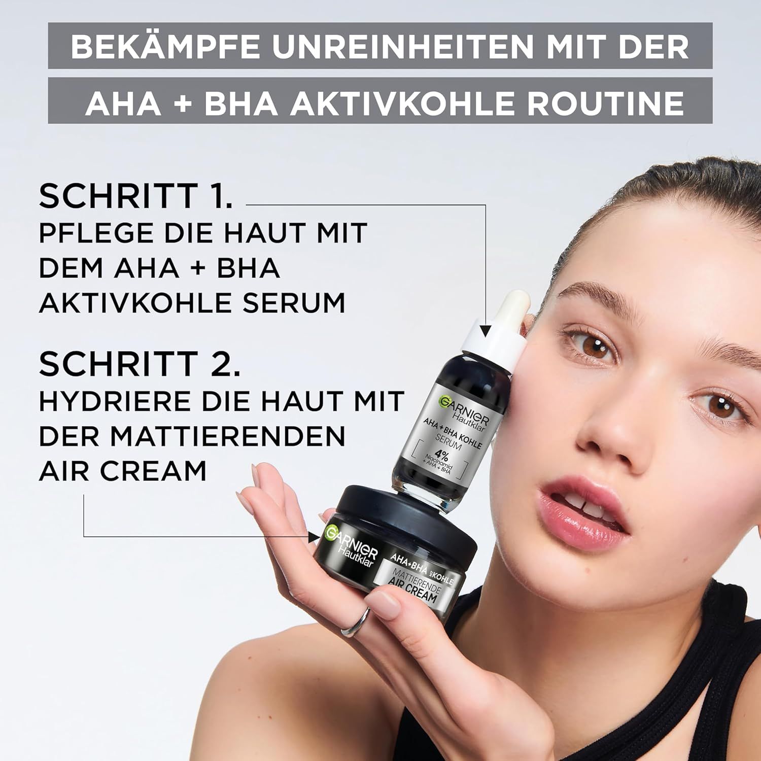 Donna che tiene il siero e la crema Garnier Hautklar AHA+BHA Kohle. Testo: Routine AHA+BHA carbone attivo.