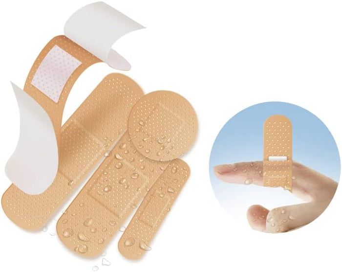 Diverse forme di cerotti. Cerotti rotondi e allungati con superficie idrorepellente. Un cerotto è mostrato su un dito.
