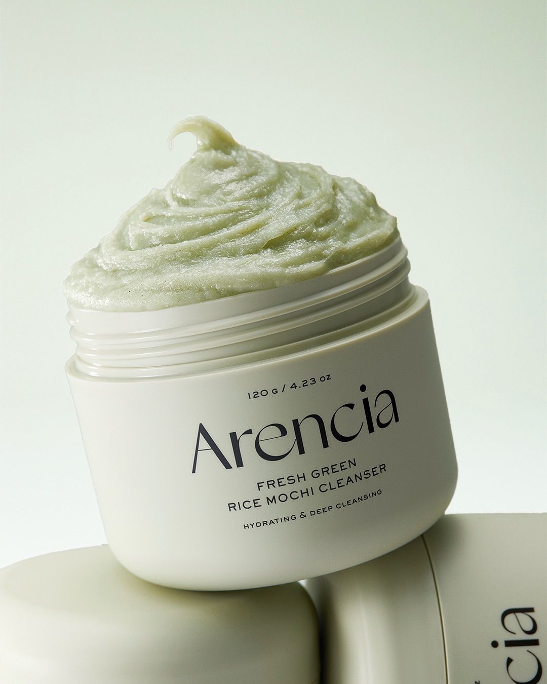 Vaso aperto con detergente mochi verde. Scritta: Arencia, Fresh Green Rice Mochi Cleanser, Hydrating & Deep Cleansing. 120g / 4.23 oz.