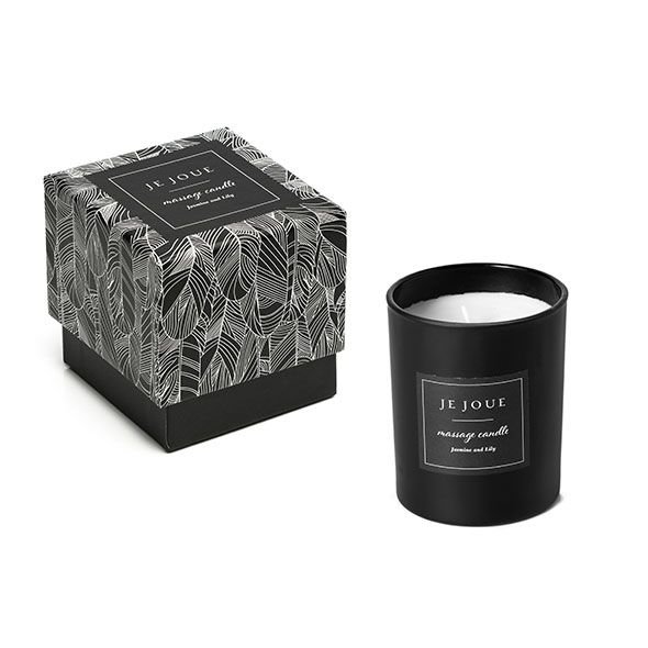 Candela nera con etichetta e scatola con motivo a piume. Scritta: Je Joue, massage candle, Jasmine Lily.