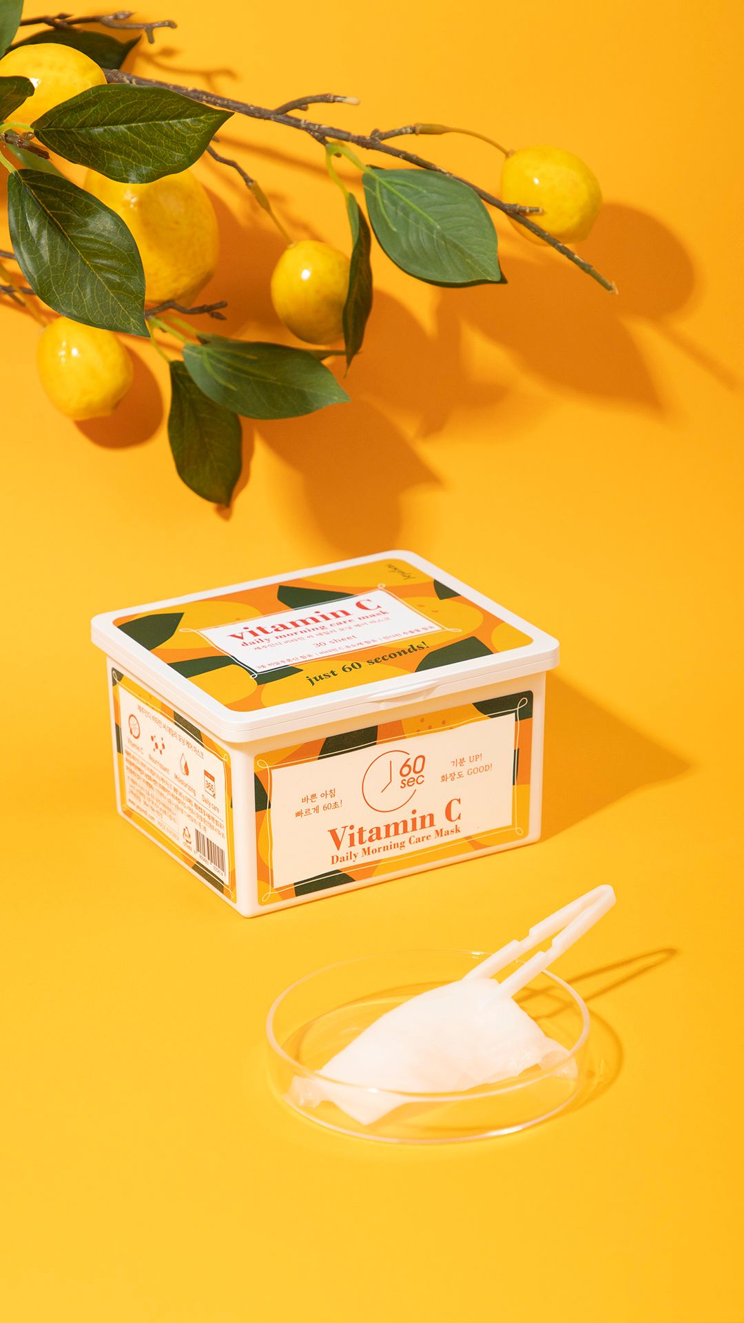 Contenitore di maschere alla vitamina C, sfondo giallo. Ramo di limone. Maschera e pinzette in ciotola di vetro.