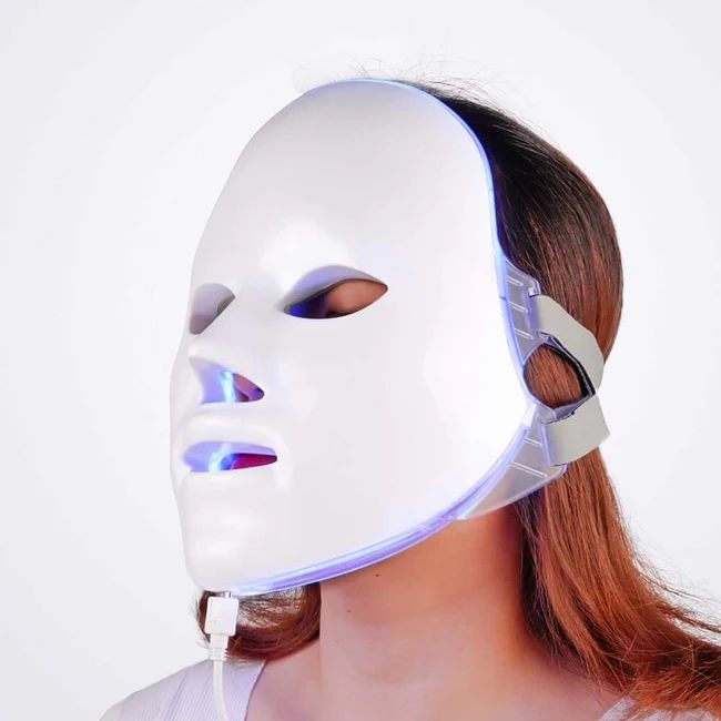 Design maschera facciale bianca su un viso. Illuminazione LED visibile. Connessione via cavo.