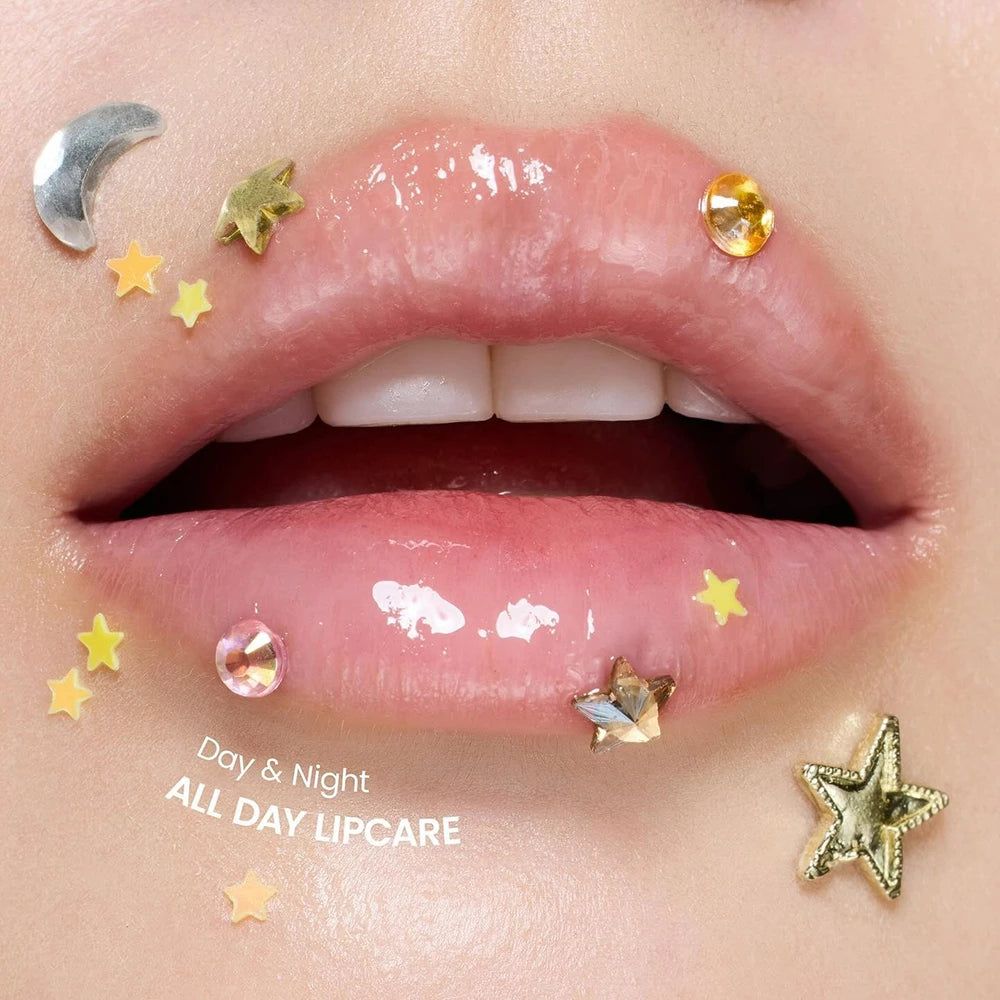 Labbra aperte e lucide, decorate con stelle e una luna. Testo: Day & Night ALL DAY LIPCARE.