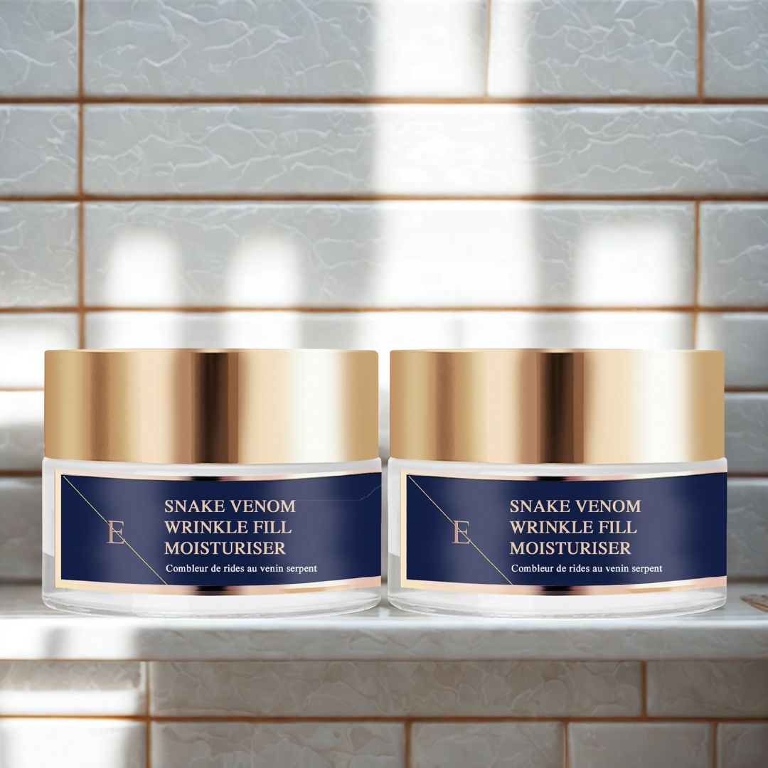 Due vasetti con coperchi dorati ed etichette blu. Scritta: Snake Venom Wrinkle Fill Moisturiser. Su una mensola bianca.