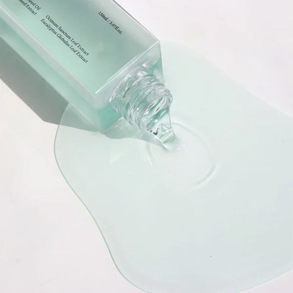 Primo piano dell'olio detergente vegano Dr. Althea Gentle Pore versato da una bottiglia su una superficie.