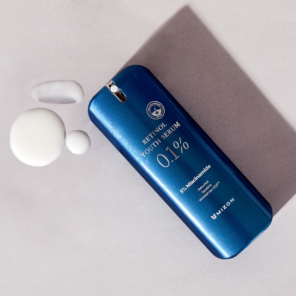 Flacone di siero blu con gocce accanto. Scritta: Retinol Youth Serum 0.1%, 5% Niacinamide, MIZON.