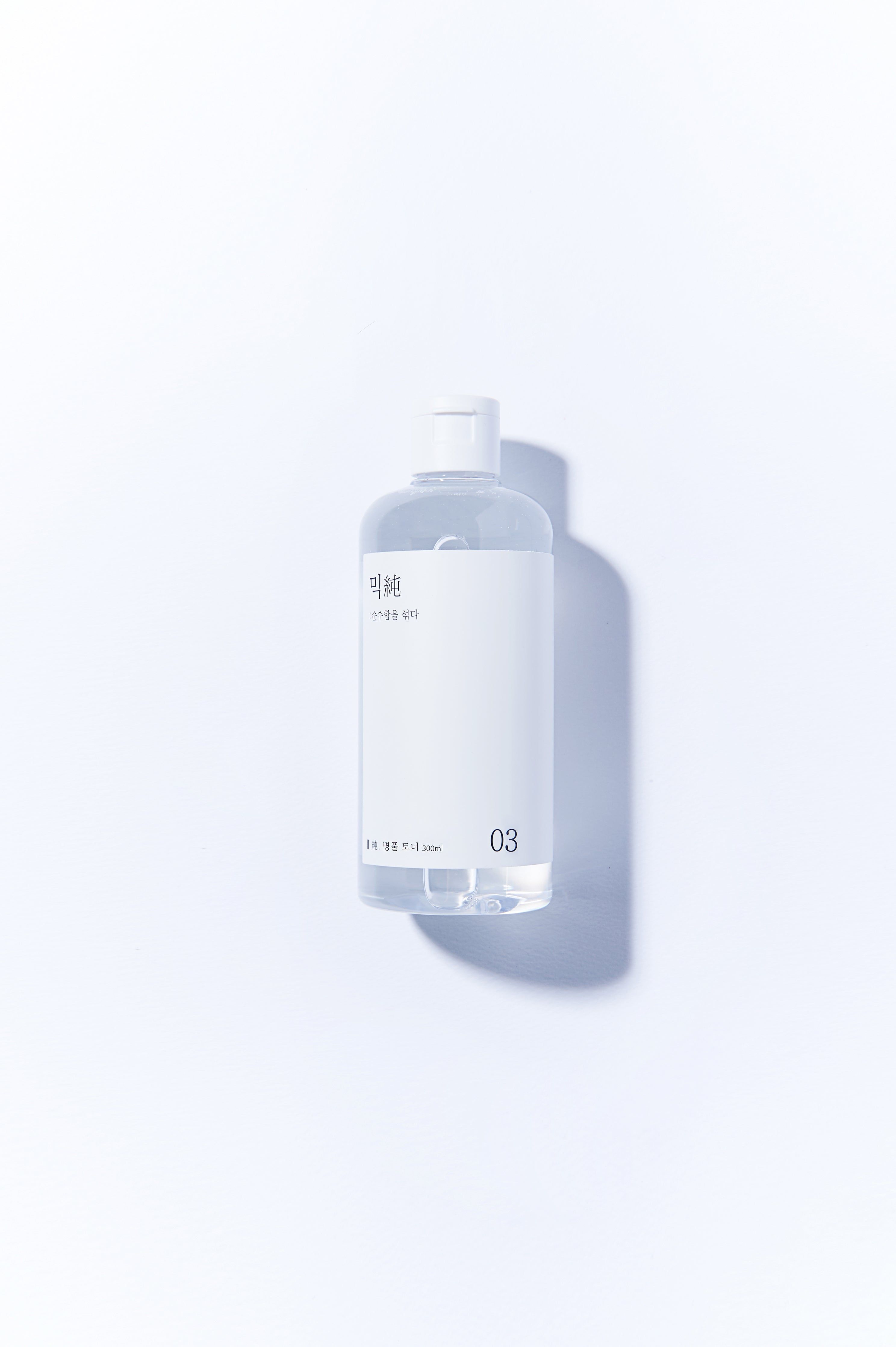 Flacone trasparente con tappo bianco ed etichetta. Scritta in coreano e il numero 03. Scritta: 200ml.