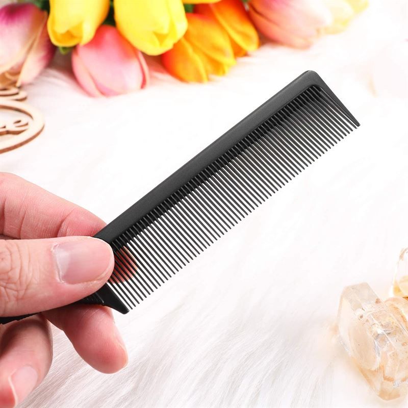 Pettine nero sottile con denti fini e un perno metallico integrato.