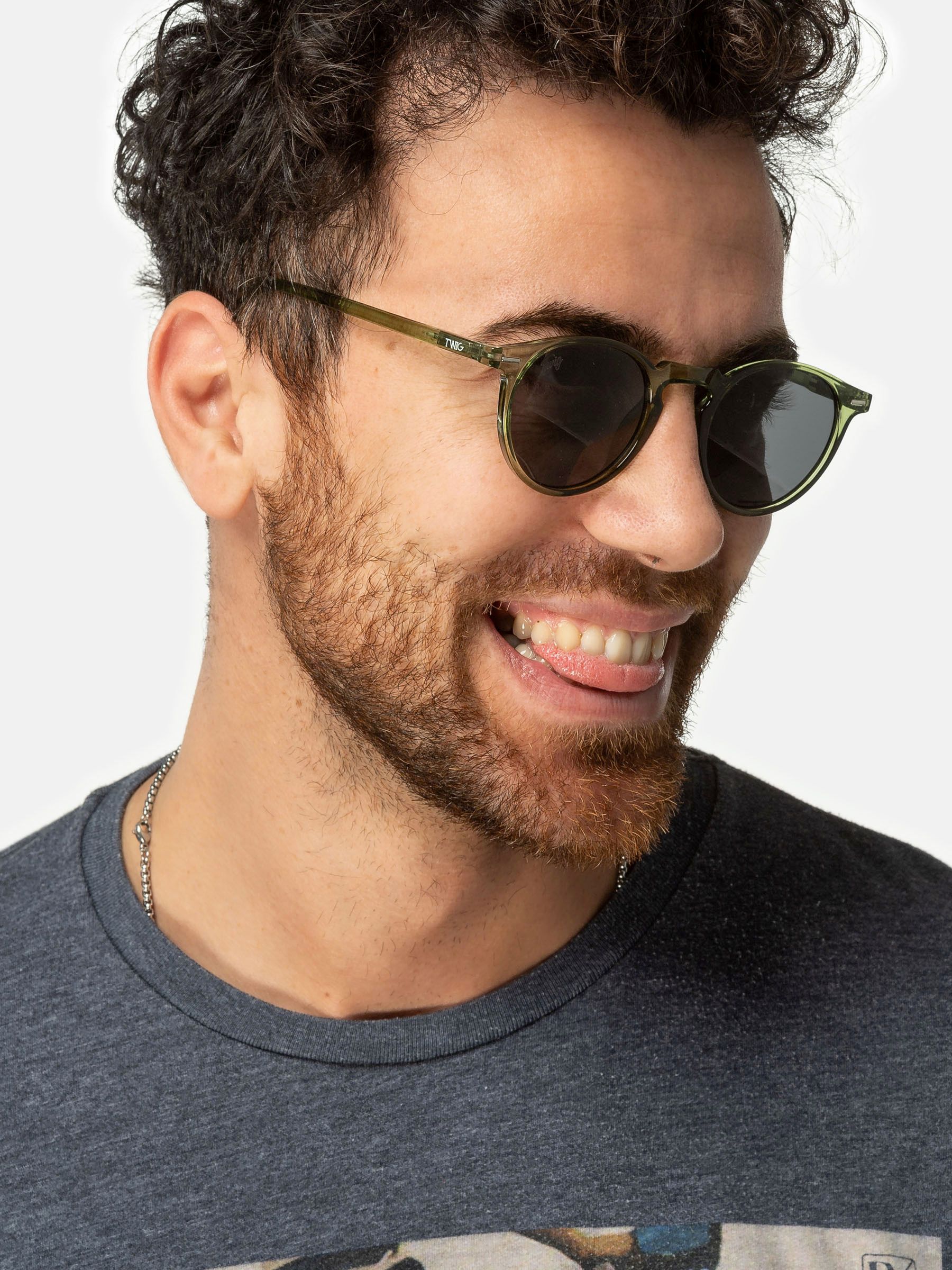 Uomo con occhiali da sole verdi. Primo piano. Mostra la lingua.