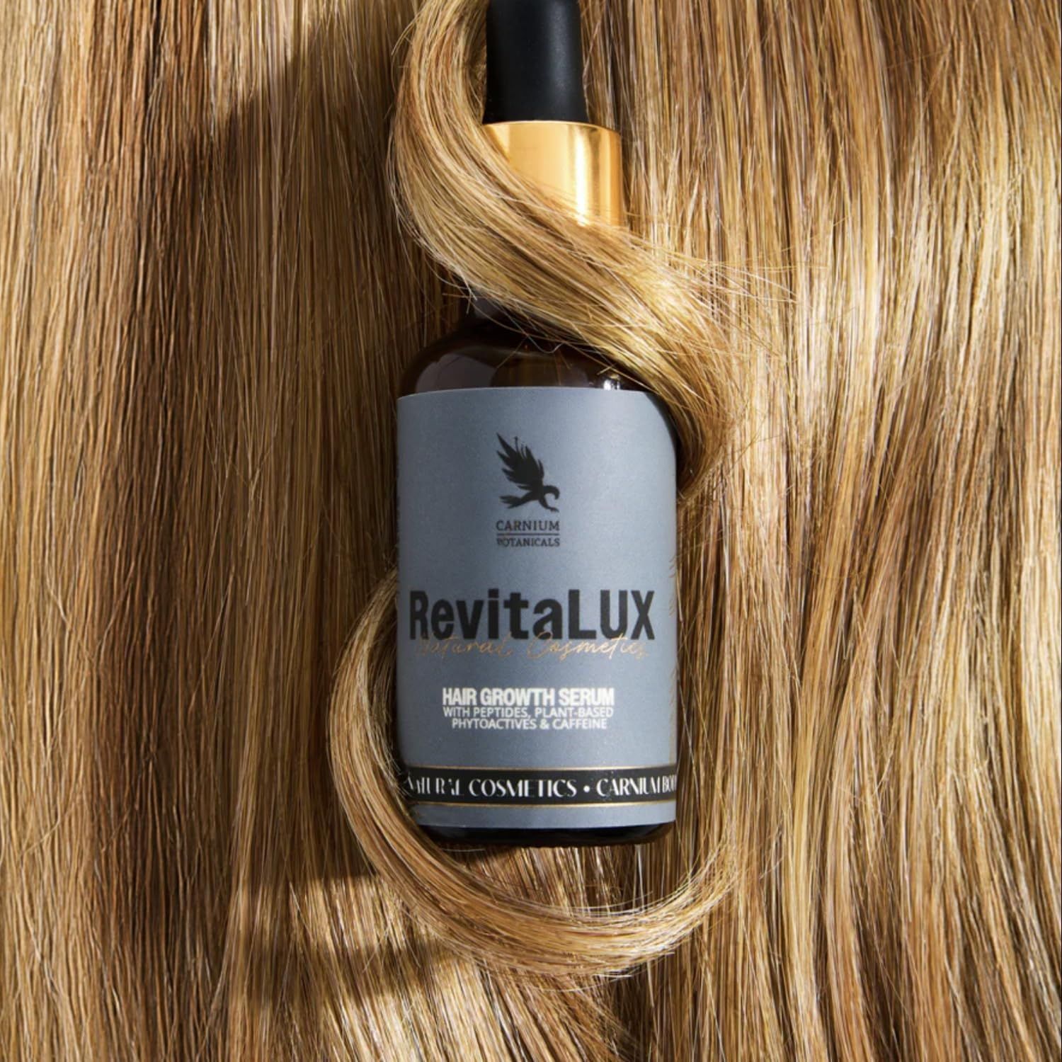 Flacone di vetro marrone con pipetta nera e tappo dorato. Nome del prodotto e logo sull'etichetta. Ciocca di capelli attorno al flacone.