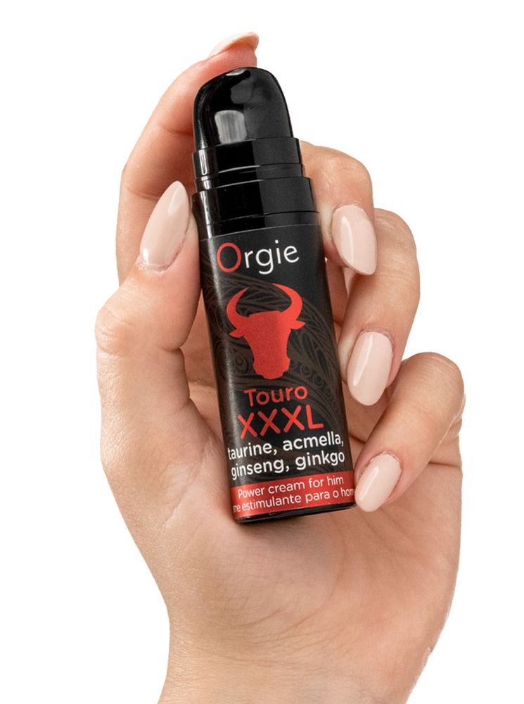 Mano che tiene un flacone: Orgie Touro XXL Power Cream. Flacone nero con testa di toro rossa. Ingredienti: Taurina, Acmella, Ginseng, Ginkgo.