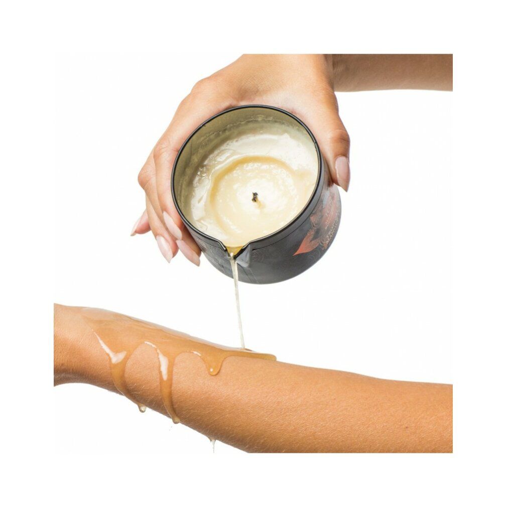 Persona versa cera fusa da una candela da massaggio su un braccio. Candela e braccio visibili.