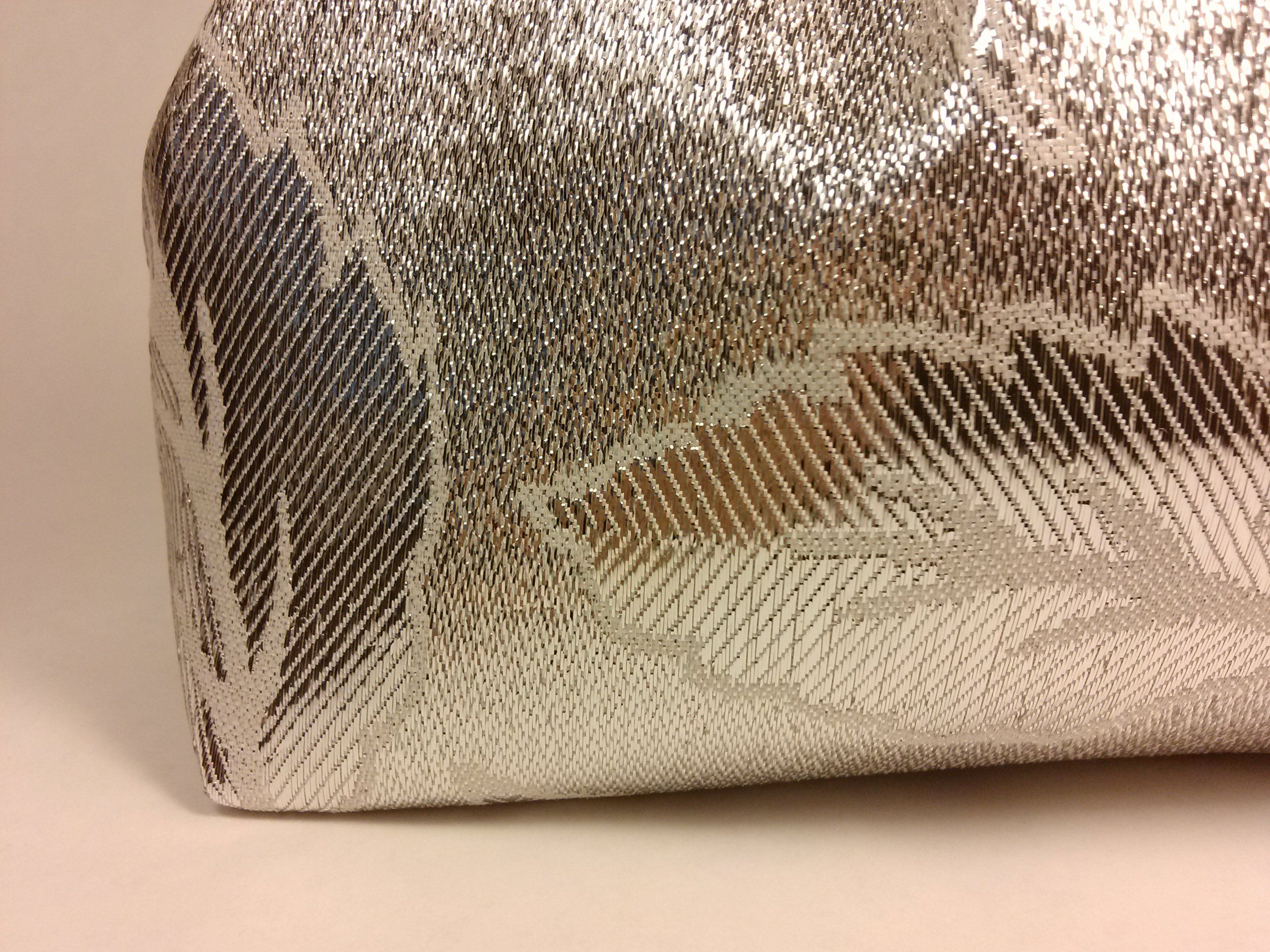 Borsa argentata con motivo floreale. Primo piano dell'angolo.