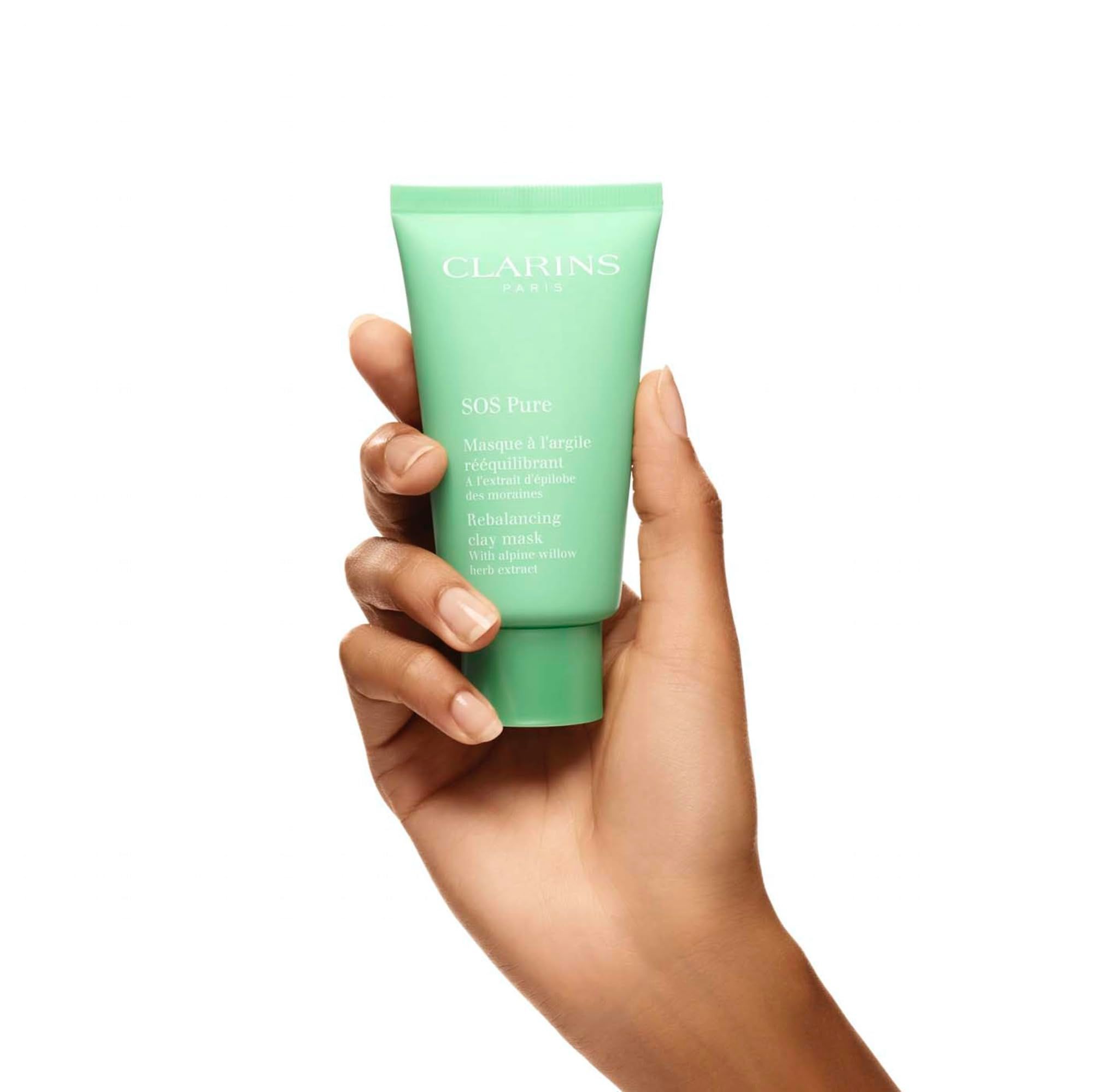 Tubo verde tenuto da una mano. Marchio Clarins. Maschera SOS Pure. Testo in francese e inglese.