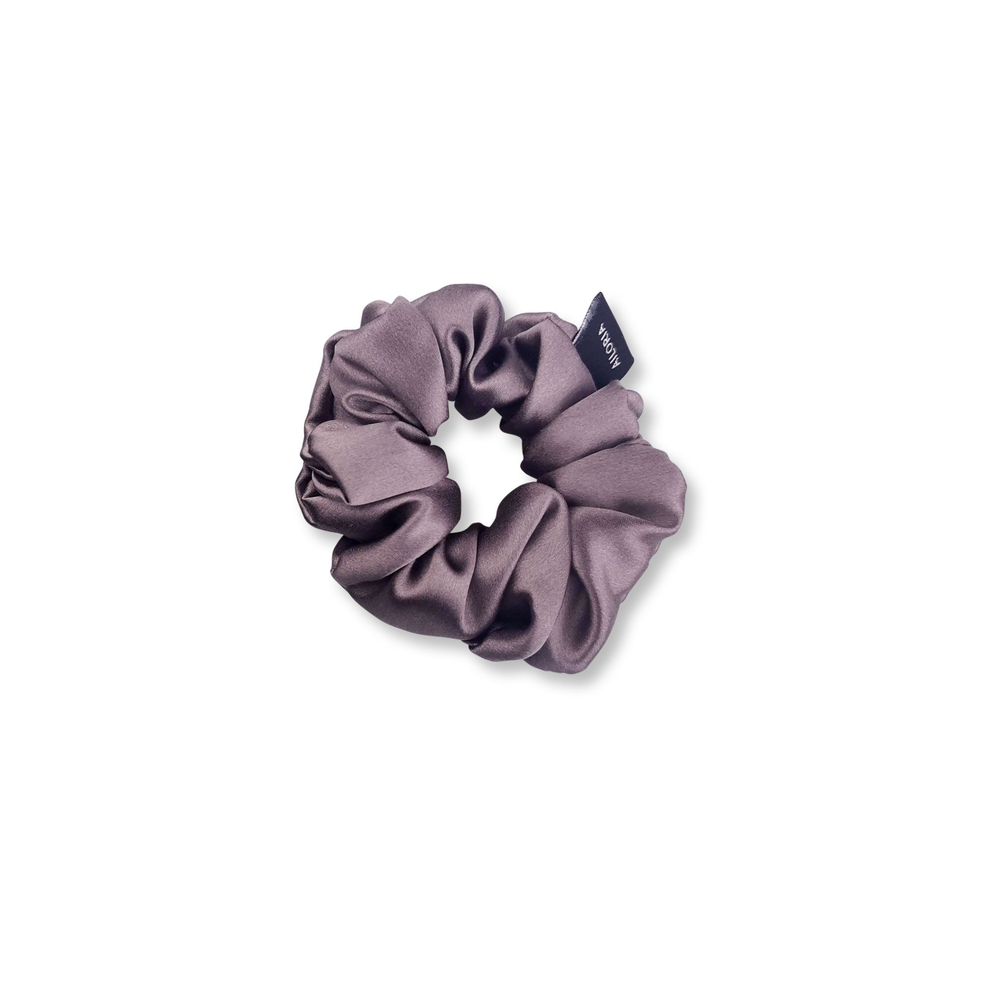 Scrunchie in seta grigia con una piccola etichetta nera.