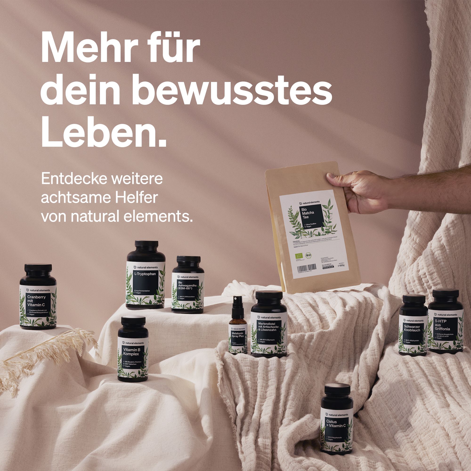 Diverse bottiglie e una busta. Testo: Di più per la tua vita consapevole. Marchio: natural elements. Prodotti presentati su una superficie.