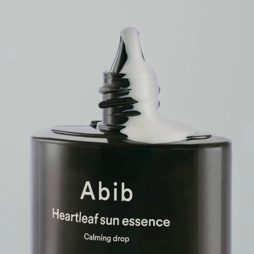 Flacone nero con crema bianca. Scritta: Abib, Heartleaf sun essence, Calming drop.