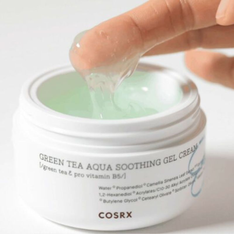 Vasetto bianco con prodotto verde-gel. Dito che tocca il gel. Scritta 'Green Tea Aqua Soothing Gel Cream' e 'COSRX'.