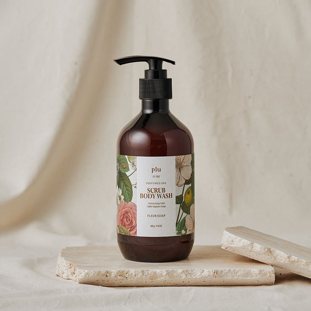 Flacone marrone con dosatore nero. Etichetta floreale con testo. Posizionato su pietra.