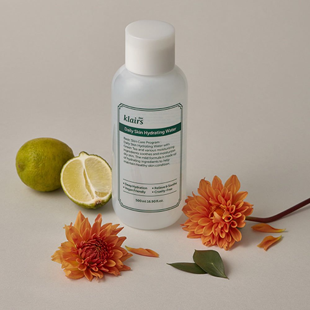 Flacone bianco con etichetta verde, accanto a lime e fiori. Scritta: "klairs Daily Skin Hydrating Water". Testo: "Deep Hydration", "Vegan Friendly", "Relieve & Soothe", "Cruelty-free".
