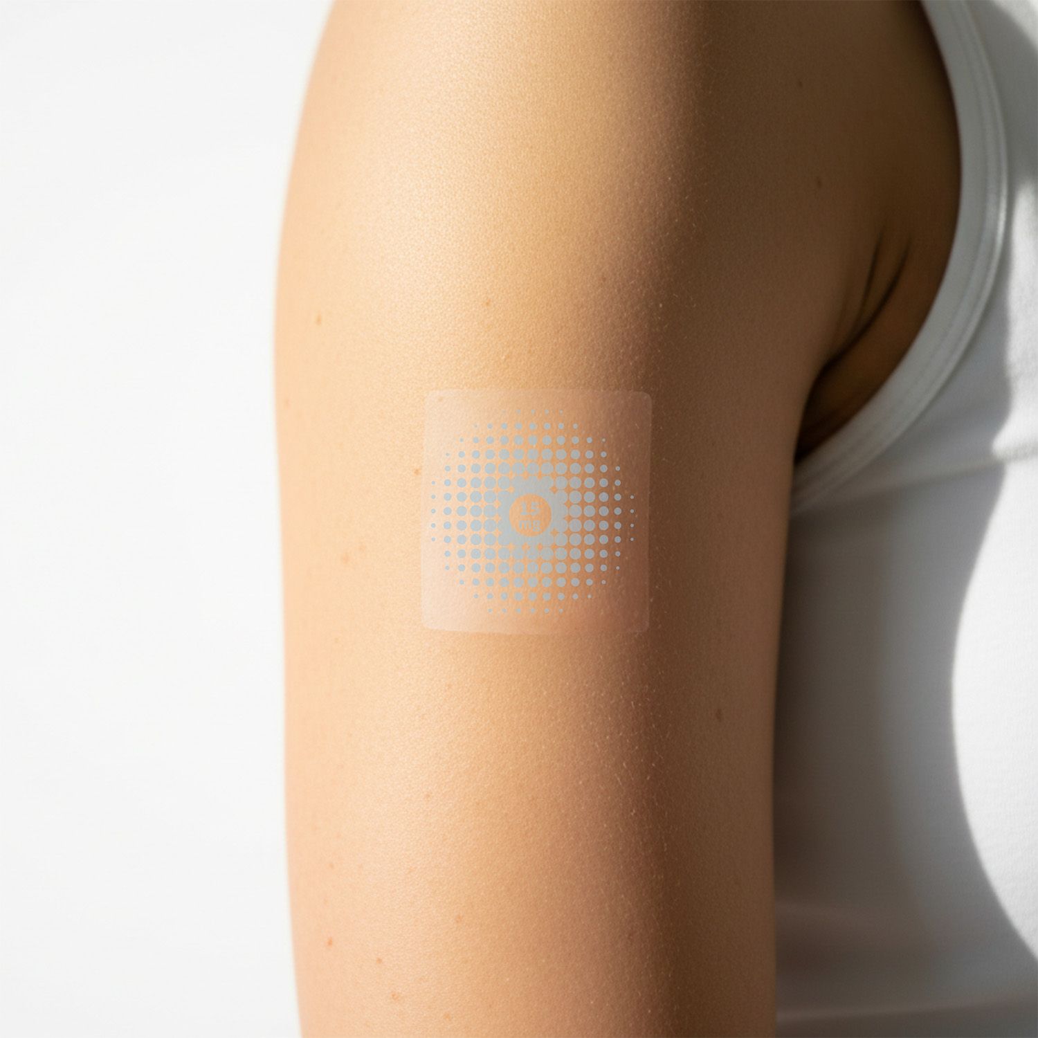 Un cerotto quadrato trasparente su un braccio. Il cerotto ha un motivo a punti blu.