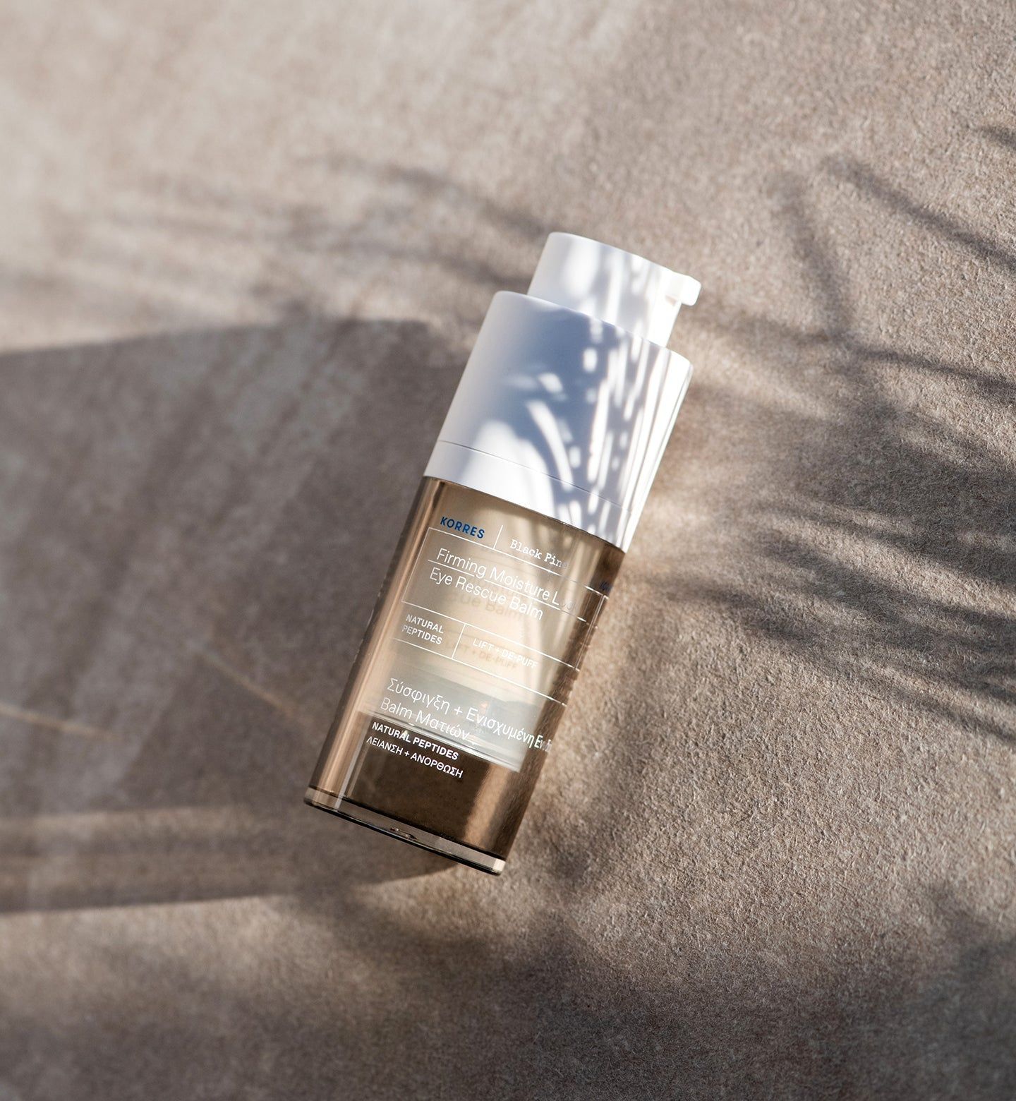 Flacone con dosatore. Marchio KORRES, nome del prodotto sull'etichetta. Su sfondo sabbia.