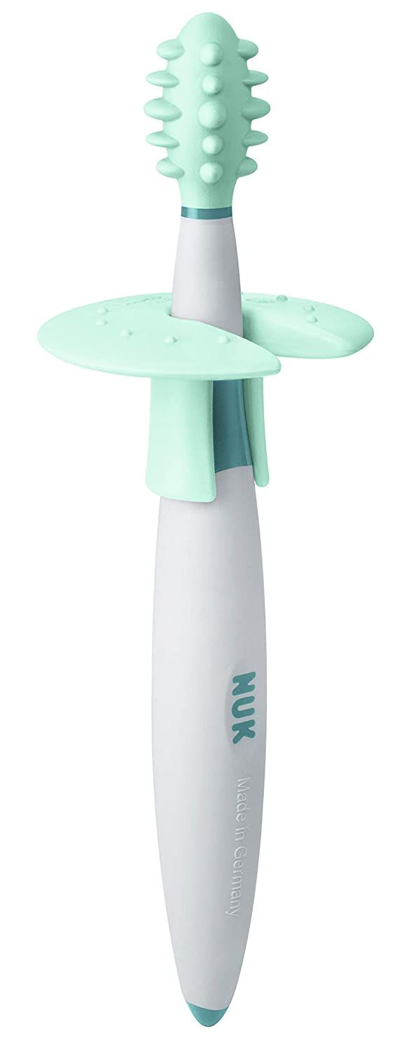 Spazzolino da allenamento con testina verde, manico bianco, parte centrale blu e anello protettivo. Logo NUK e Made in Germany.