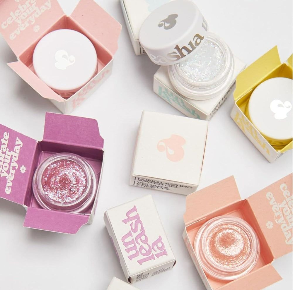 Diversi vasetti glitter in scatole. Coperchi con logo. Testo: Unleashia.