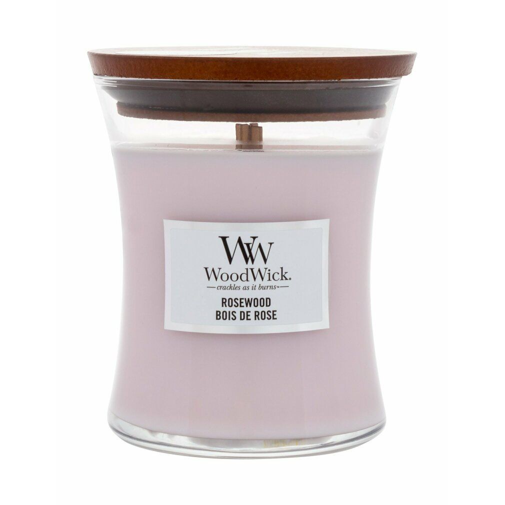 Candela a clessidra con stoppino in legno e coperchio in legno. Cera rosa, etichetta con logo e testo. Contenitore in vetro trasparente. Stoppino in legno visibile.