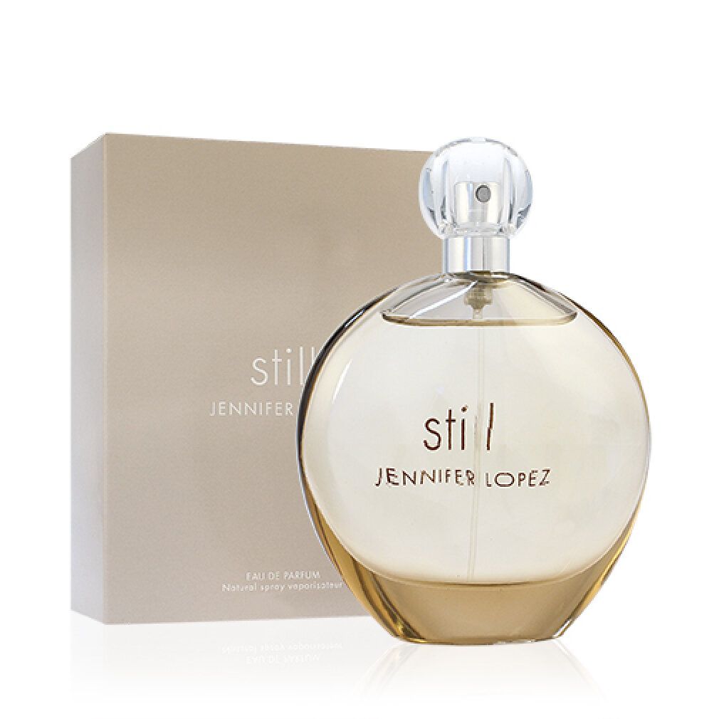 Flacone di profumo e scatola. Flacone rotondo, marrone chiaro. Scatola beige con scritta "still jennifer lopez".