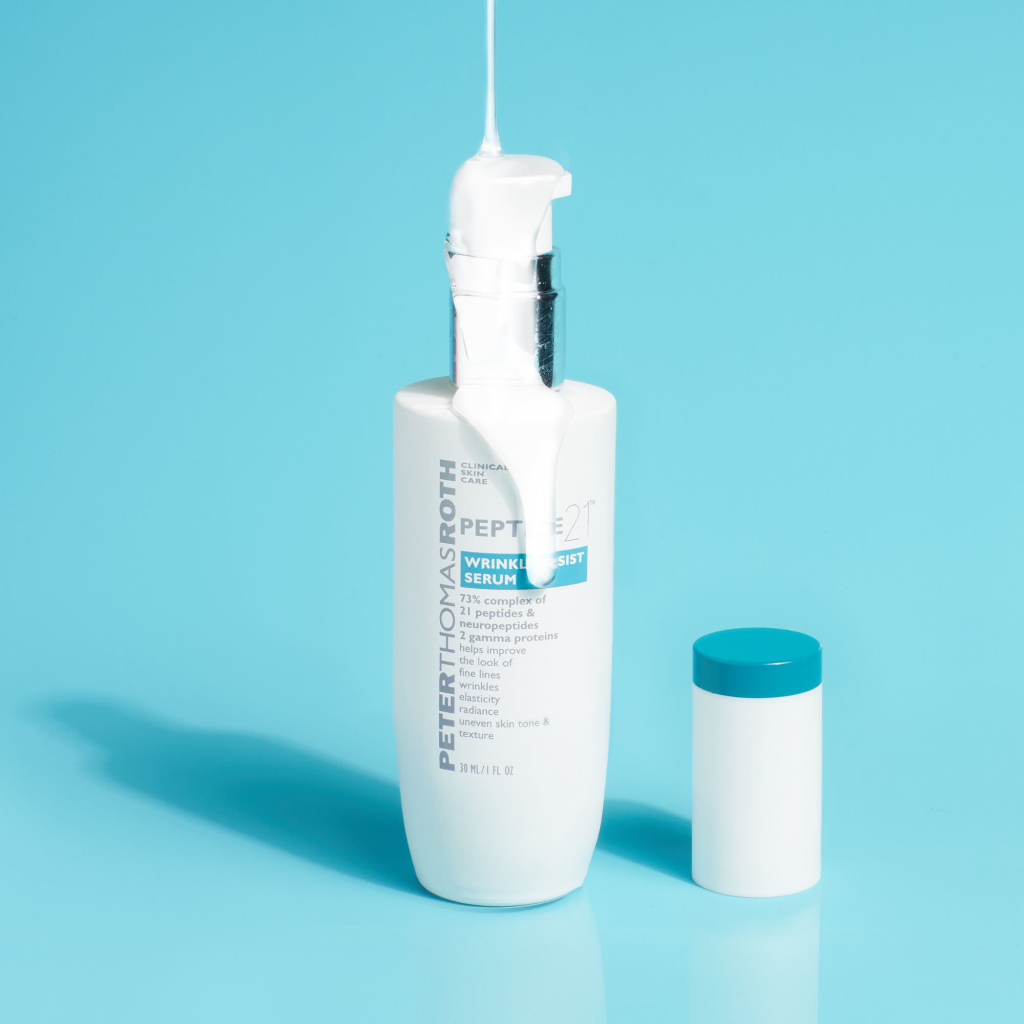 Flacone bianco con tappo blu e scritta PEPTIDE 21. Prodotto versato dal flacone.