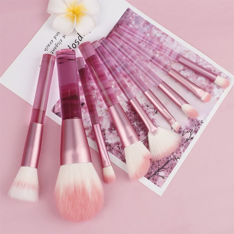 Set di pennelli per trucco rosa. Diversi pennelli con manici trasparenti e setole rosa. Su sfondo rosa.