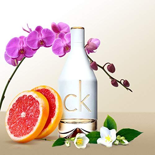 Flacone di profumo con orchidee, pompelmo e fiori di gelsomino.