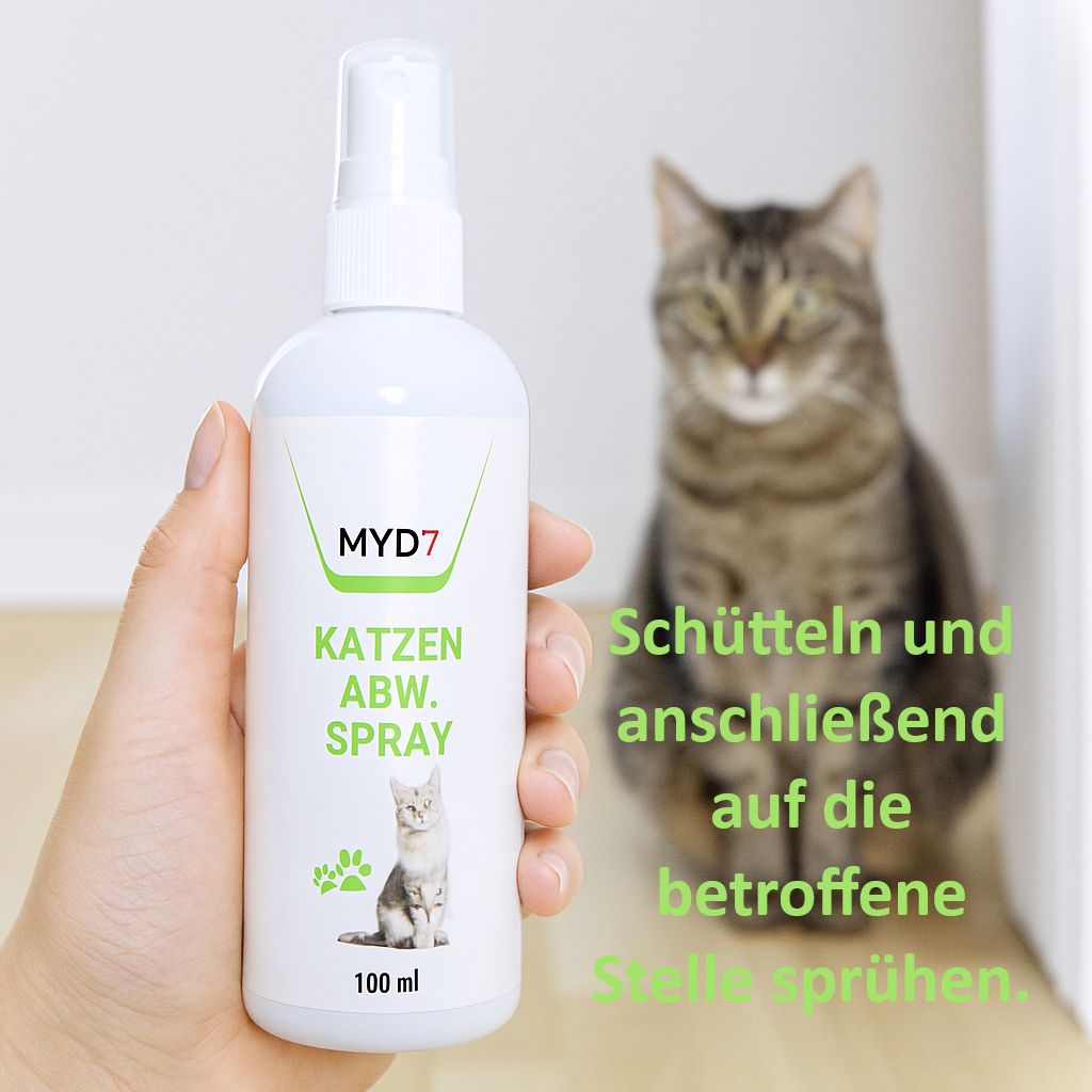 Flacone spray bianco con logo MYD7 e "Katzen Abw. Spray". Mano che tiene il flacone, gatto sullo sfondo.