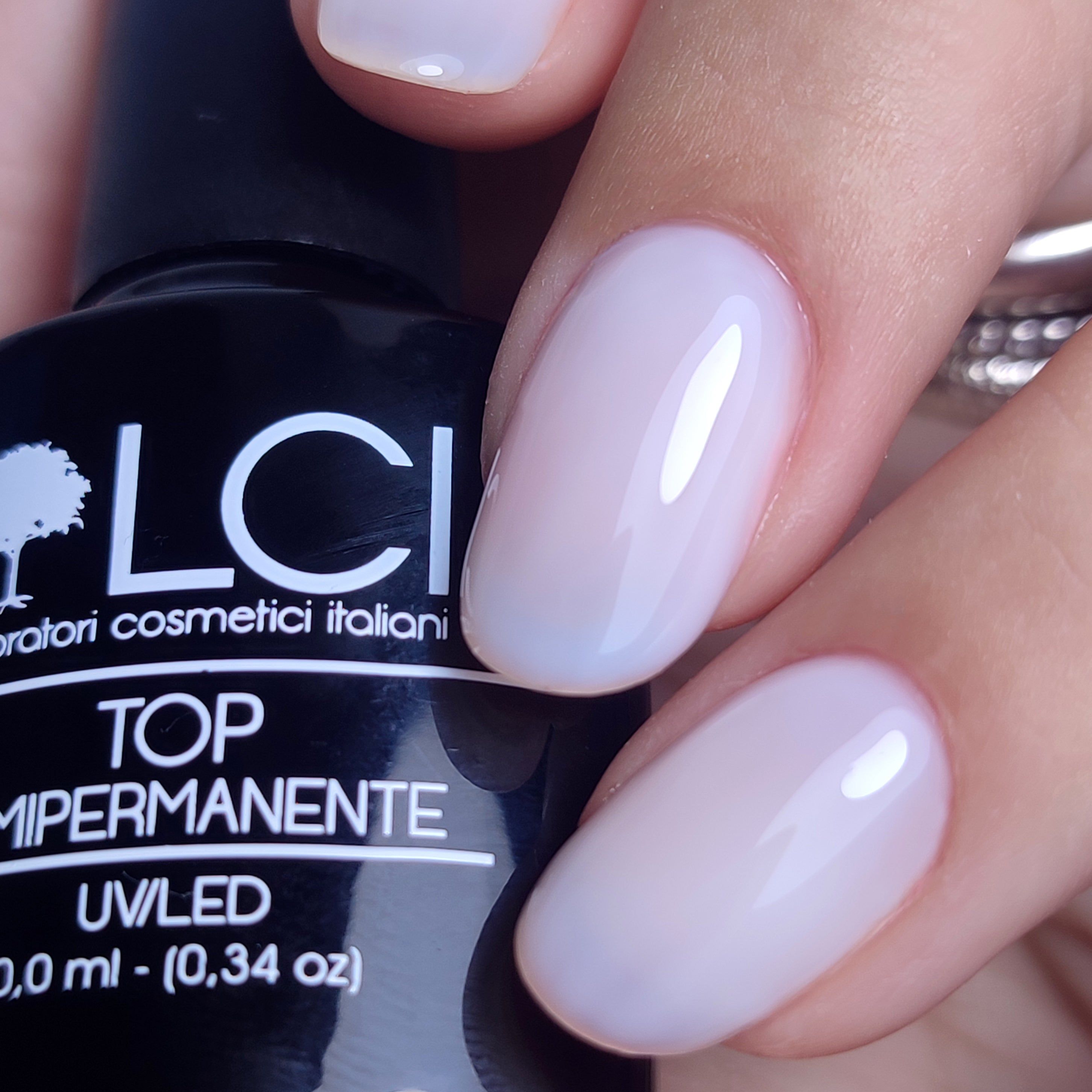 Primo piano di unghie smaltate. Scritta: TOP SEMIPERMANENTE, UV/LED. Marchio LCI.