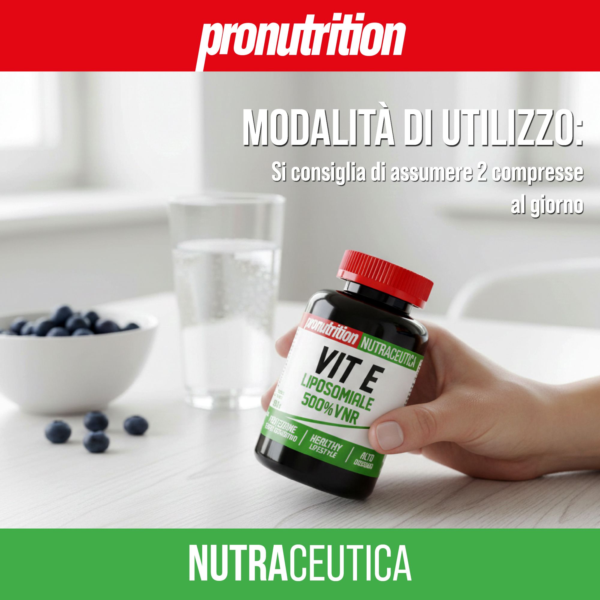 Una mano tiene in mano un flacone con tappo rosso. Scritta: Vit E Liposomiale 500%VNR. Bicchiere d'acqua e mirtilli sul tavolo.