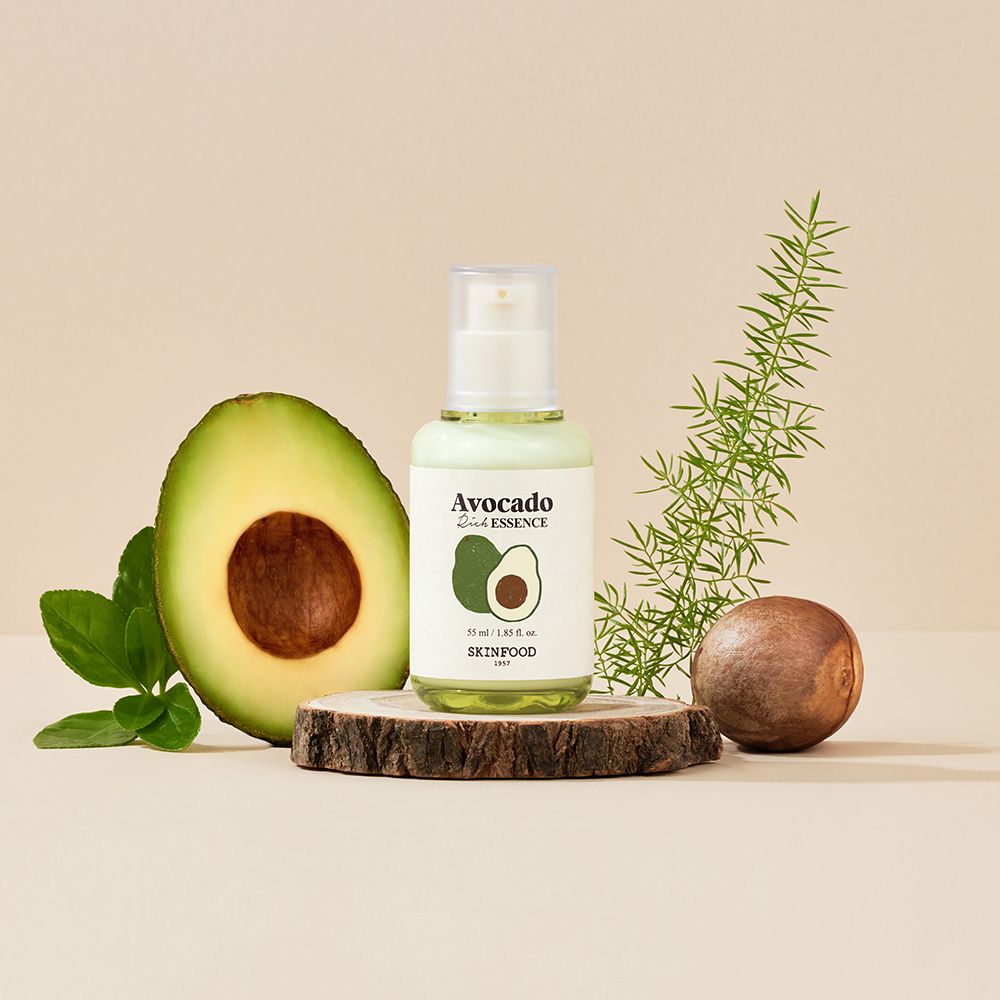 Flacone di siero con illustrazione di avocado, su ceppo di legno. Metà avocado, ramo e nocciolo.