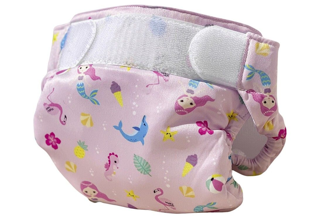 Pannolino da bagno rosa con motivi di sirene ed estivi. Chiusure in velcro. Pannolino in tessuto.