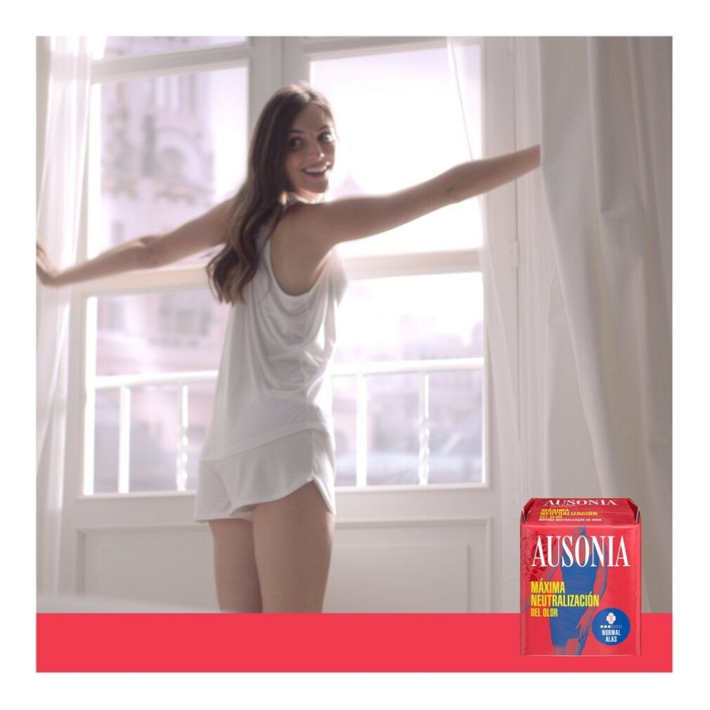 Donna apre le tende. In primo piano: confezione Ausonia. Confezione rosa con logo e informazioni.