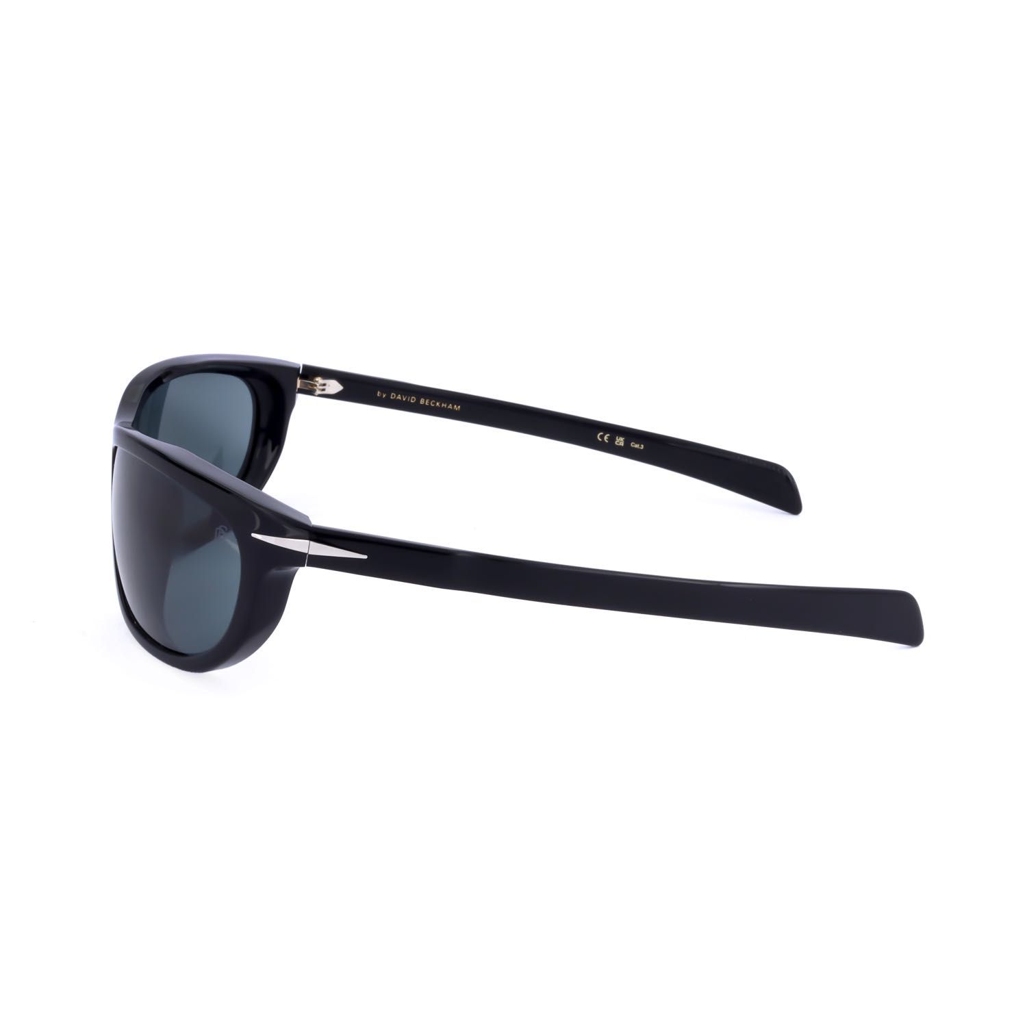 Occhiali da sole neri con lenti scure e accenti argentati sulle aste. Scritta 'BY DAVID BECKHAM'.